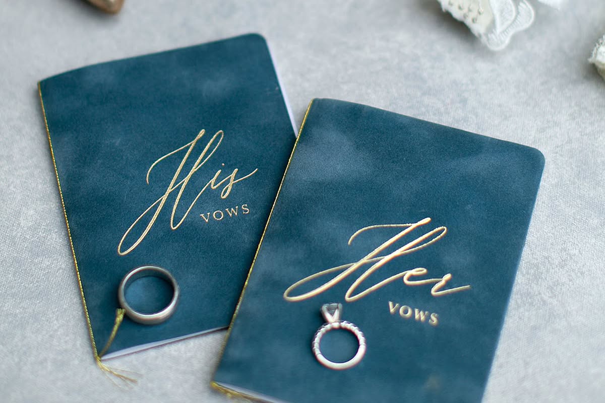 Bride and groom vow books with wedding rings, shoes, and personal details.