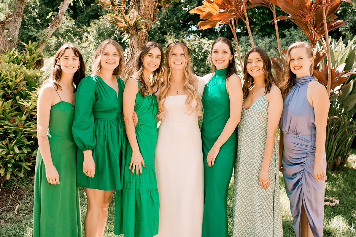 Bride standing with bridesmaids in green dresses during a private residence wedding.