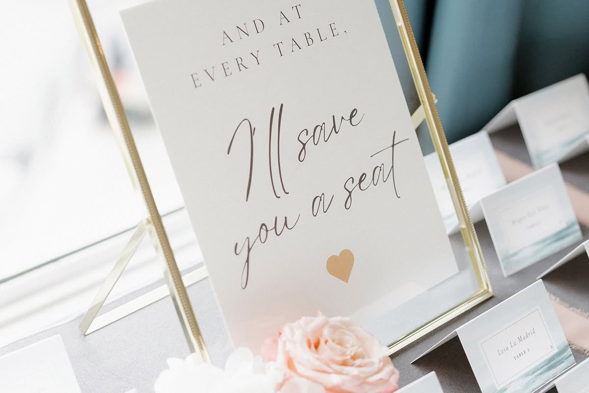 Wedding escort card display with a sign reading I will save you a seat.