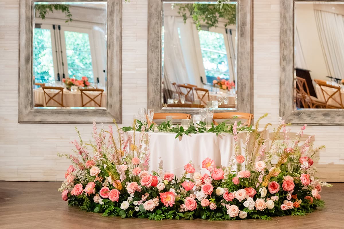 Sweetheart table framed by hanging greenery and colorful florals at Estancia La Jolla Hotel & Spa.