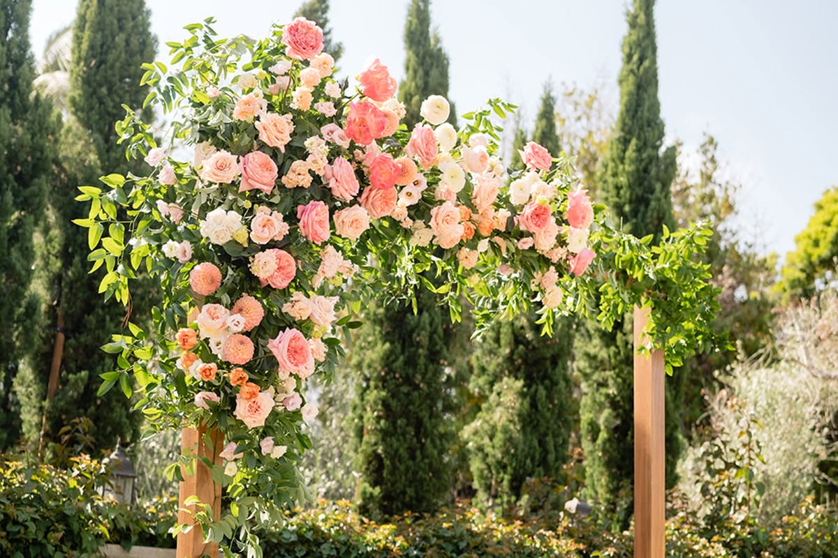 Colorful garden wedding ceremony arch with pink, coral, and peach flowers at Estancia La Jolla Hotel & Spa.