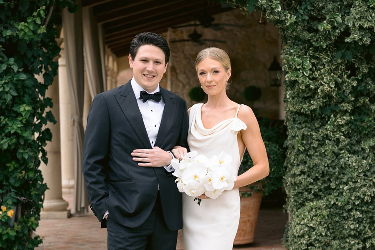 Bride and groom standing beneath an ivy-covered doorway at A Table on the Hill.